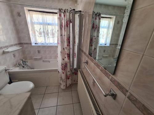 a bathroom with a toilet and a tub and a shower at Mesa property services in Grays Thurrock