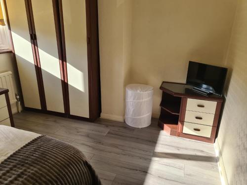 Mesa property services في غرايس ثوروك: غرفة نوم مع سرير وتلفزيون في خزانة