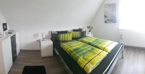 a bedroom with a bed with yellow and green sheets at Gemütlich mit Blick auf die Burg.Autobahnanbindung in Untergruppenbach