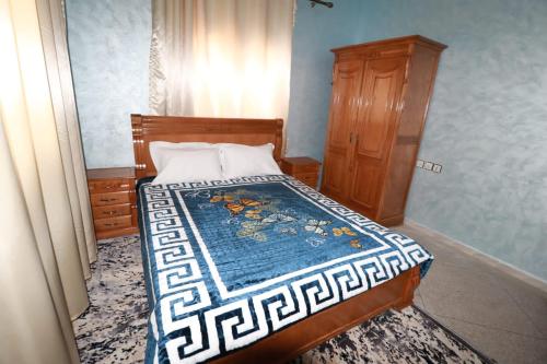 a small bedroom with a bed and a dresser at حي الشهداء in Laayoune