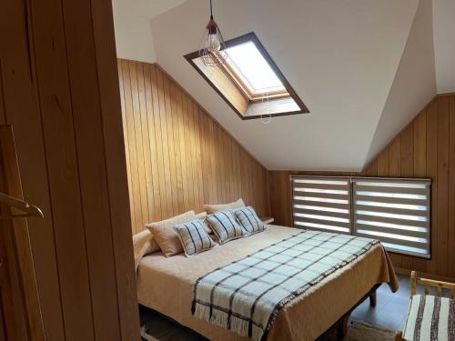 1 dormitorio con 1 cama y tragaluz en Hotel Boutique Arca Restaurant Achao Quinchao Chiloe, en Achao