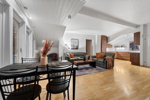 uma sala de jantar e sala de estar com mesa e cadeiras em View of Tromsø em Tromsø
