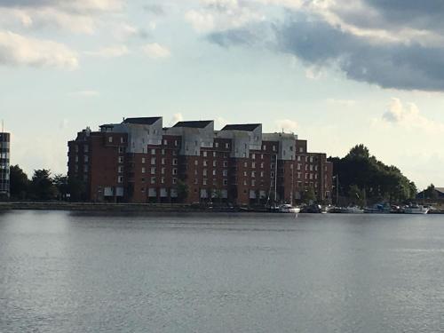 a large building sitting on the side of a body of water at Schönes Feriendomizil mit Meerblick Südstrand Nähe Fliegerdeich in Wilhelmshaven in Wilhelmshaven
