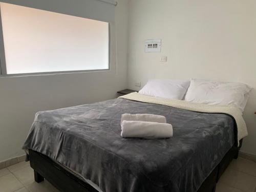 Una cama con una toalla blanca encima. en Apartaestudio de la 80 por el Titán Plaza 101 en Bogotá