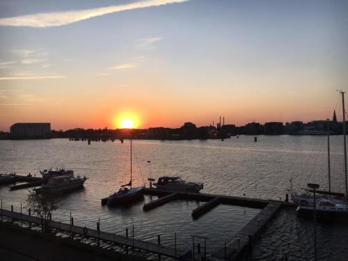 a group of boats docked at a dock at sunset at Schönes Feriendomizil mit Meerblick Südstrand Nähe Fliegerdeich in Wilhelmshaven in Wilhelmshaven