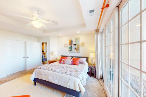 1 dormitorio con 1 cama y ventilador de techo en The Sandbridge Dunes - A Beach Delight 116 en Virginia Beach