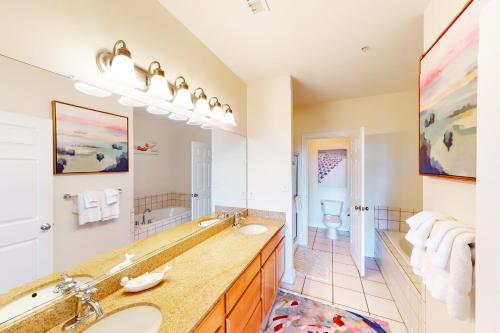 baño con 2 lavabos y espejo grande en The Sandbridge Dunes - A Beach Delight 116, en Virginia Beach
