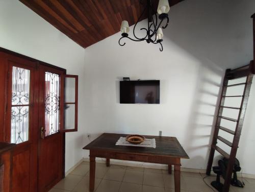 a room with a table and a television on the wall at Pousada L'étage in Búzios