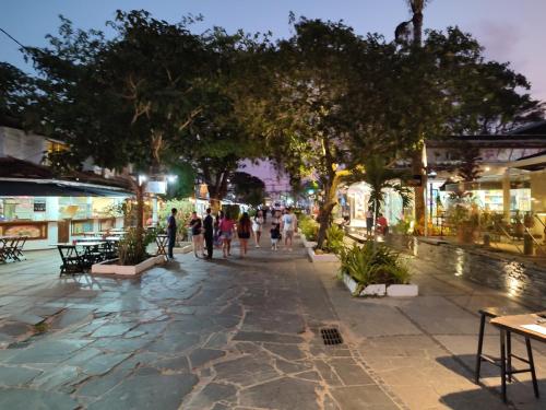 a group of people walking down a street at night at Pousada L'étage in Búzios