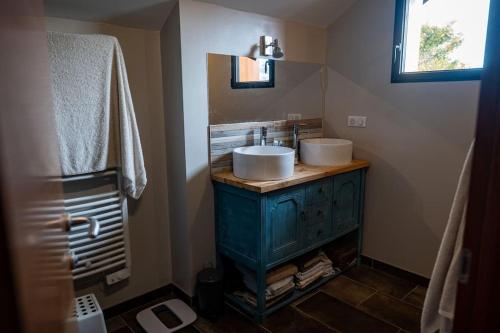 uma casa de banho com um lavatório e um espelho em logement entier au calme em Étercy