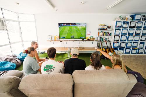 a group of people sitting on a couch watching tv at Mad Monkey Waterfront in Cairns