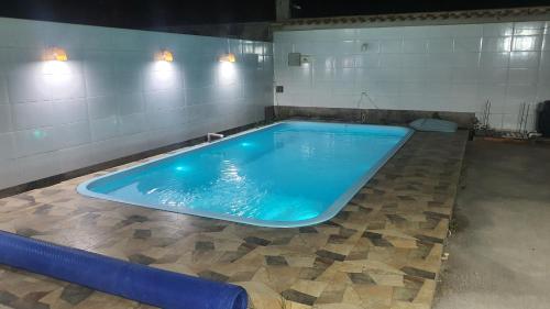a large blue swimming pool in a room at Casa para Temporada Praia Grande in Fundão