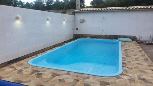 a large blue swimming pool sitting on a patio at Casa para Temporada Praia Grande in Fundão