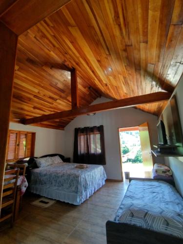 布埃諾布蘭的住宿－Chalés Encantos de Minas，一间卧室设有两张床和木制天花板