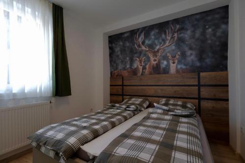 two beds in a room with deer on the wall at Apartman Moon Jahorina in Pale