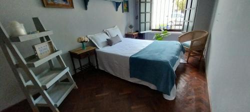Un dormitorio con una cama con una manta azul encima. en Los Aceres, en Salta