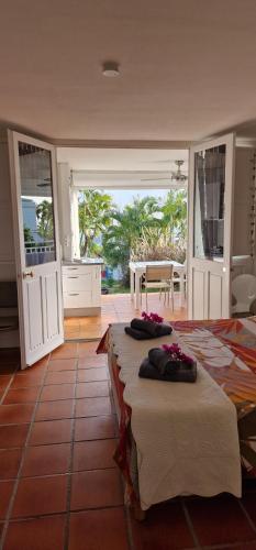 une chambre avec deux lits et une cuisine avec portes coulissantes dans l'établissement Anse des rochers - Ti Kaz MiLouMa, à Saint-François