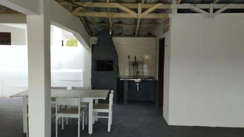 a dining room with a white table and chairs at Casa em Shangri-lá perto da praia para até 10 pessoas in Pontal do Paraná
