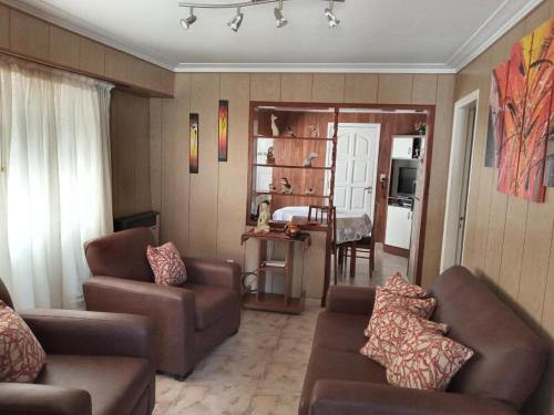 sala de estar con sofá y silla en “Chalet Carrasco” totalmente equipado en Mar del Plata