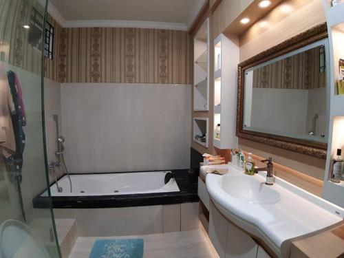a bathroom with a bath tub and a sink and a bath tub at TITE homestay. Staycation feels @home in Salakan