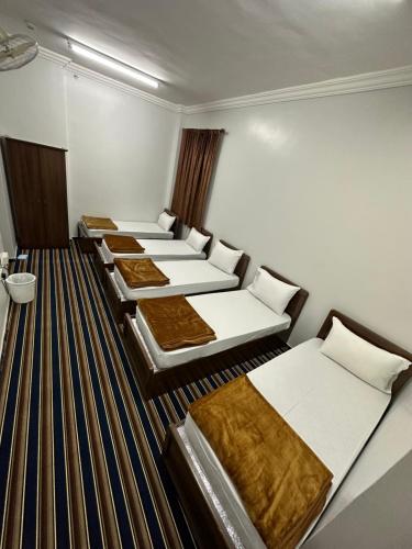 a row of beds in a room at فندق المقام الراقي للشقق والغرف المفروشة in Makkah
