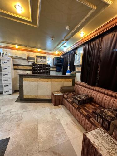 een woonkamer met een bank en een bar bij فندق المقام الراقي للشقق والغرف المفروشة in Mekka