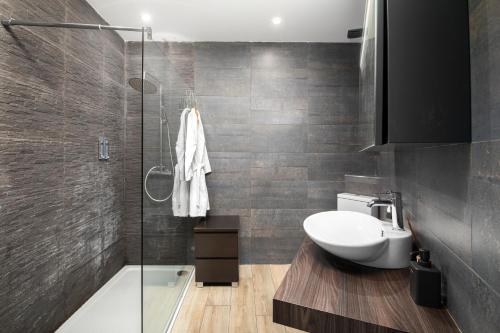 Luxury Msida Circle Suites في مسيدا: حمام مع حوض ومرحاض ودش