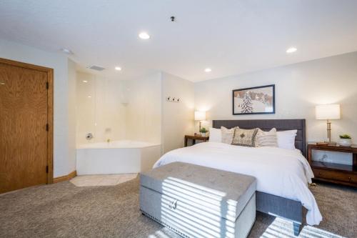 a bedroom with a large bed and a bath tub at Powder Hound 1 Bedroom Brighton Chalet in Brighton