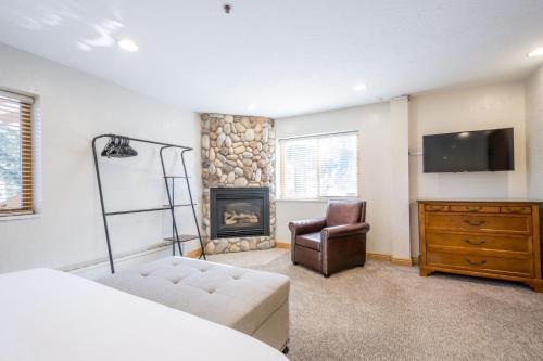 a bedroom with a bed and a fireplace and a tv at Powder Hound 1 Bedroom Brighton Chalet in Brighton