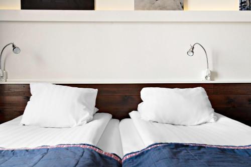 a bed with two white pillows and two lights on it at Best Western Hotel Arctic Eden in Kiruna