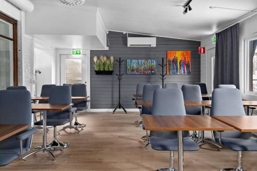 a conference room with wooden tables and blue chairs at Best Western Hotel Arctic Eden in Kiruna