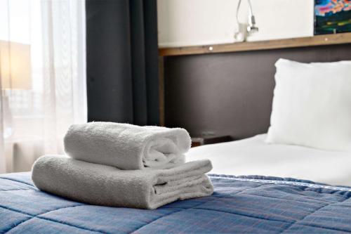 a stack of towels sitting on top of a bed at Best Western Hotel Arctic Eden in Kiruna