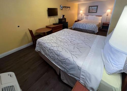 a hotel room with two beds and a desk at Motel 6 San Francisco CA Fisherman"s Wharf in San Francisco