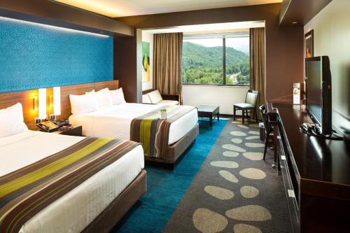 a hotel room with two beds and a large window at Harrah's Cherokee Casino Resort in Cherokee