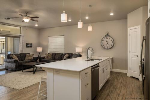 a kitchen and living room with a clock on the wall at S404-The Penthouse-Fourth Floor 3-bedroom Pool View in St. George