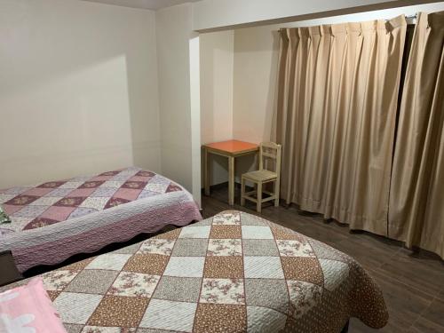 a bedroom with two beds and a table and a table at 9 de octubre in Oruro