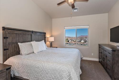 um quarto com uma cama e uma televisão de ecrã plano em S404-The Penthouse-Fourth Floor 3-bedroom Pool View em St. George