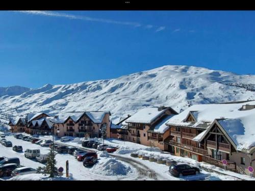 a town with a snow covered mountain in the background at Valmeinier in Valmeinier