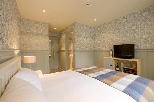 a bedroom with a bed and a flat screen tv at Brooks Guesthouse Bristol in Bristol