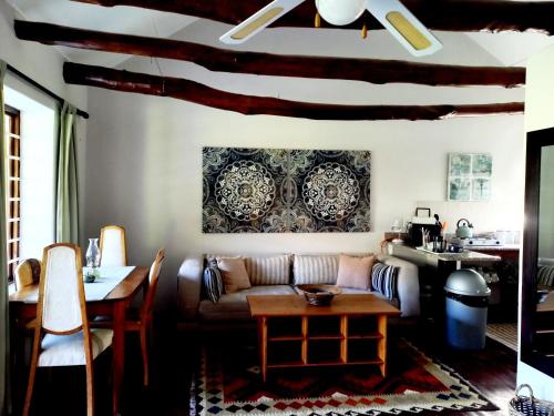 a living room with a couch and a table at Aloe Valley Retreat in Oudtshoorn