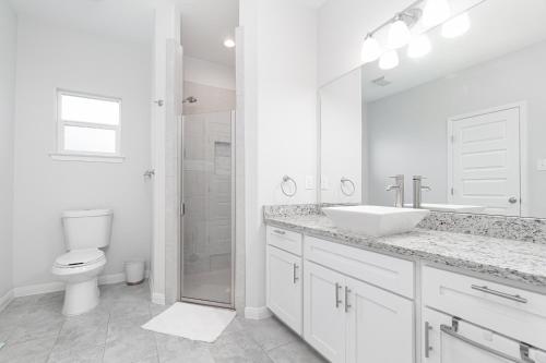 Baño blanco con lavabo y aseo en 1 Story-4BR/5Beds/2.5BA Lackland-Missions-Downtown en San Antonio