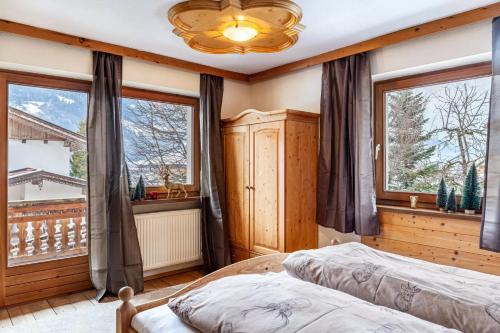 a bedroom with two beds and a large window at Ferienwohnung Platzhirsch Panorama View Balkon, Gartensauna, Garten, Grillplatz in Stumm