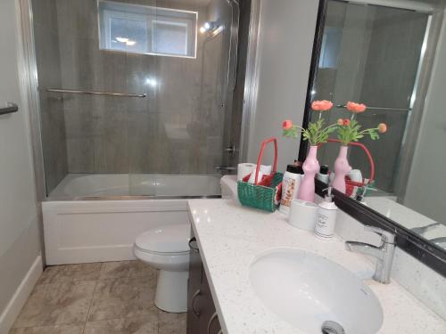 a bathroom with a sink and a toilet and a tub at Oscar INN & 2bd Family Suite or Private Room in Abbotsford