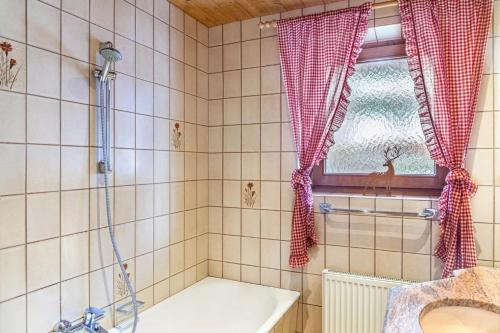 ein Bad mit einer Badewanne, einer Dusche und einem Waschbecken in der Unterkunft Ferienwohnung Platzhirsch Panorama View Balkon, Gartensauna, Garten, Grillplatz in Stumm