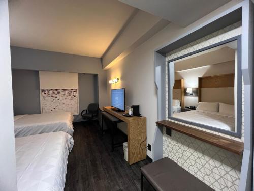 a hotel room with two beds and a desk with a computer at Holiday Inn Uruapan by IHG in Uruapan del Progreso