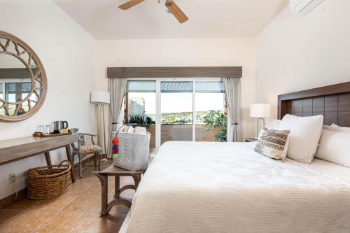 a bedroom with a bed and a desk and a window at LC 1A- Beach Club & Housekeeping included - Golf Cart in La Paz