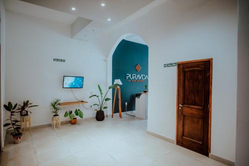 a hallway with a door and potted plants at Pura Vida Concordia in Concordia