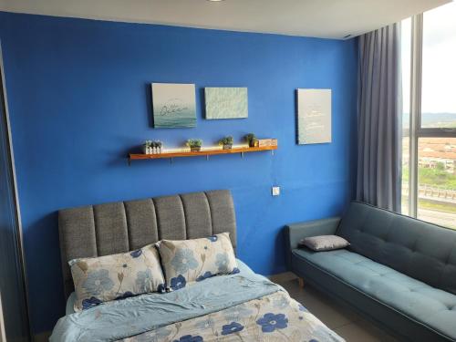 een blauwe slaapkamer met een bank en een blauwe muur bij Seri Kembangan Facilities Level Free WIFI Cozy Home - 3Elements in Seri Kembangan