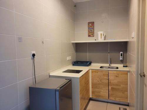 a small kitchen with a sink and a stove at Seri Kembangan Facilities Level Free WIFI Cozy Home - 3Elements in Seri Kembangan