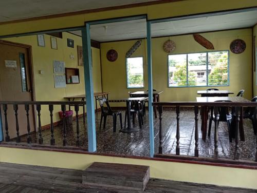 a restaurant with tables and chairs and windows at AA Homestay in Mulu